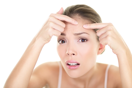 young woman looking upset with fingers on face