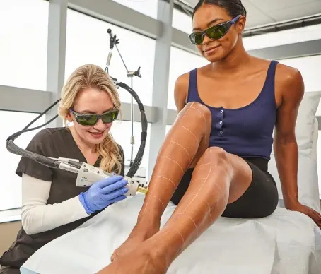 Young woman at Ideal Image medspa receives laser hair removal treatment on her legs