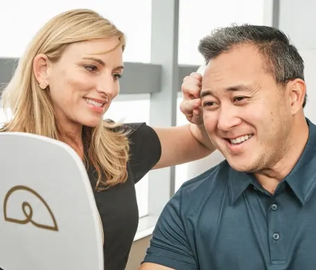 Man looking in mirror discussing Botox with Ideal Image medical professional