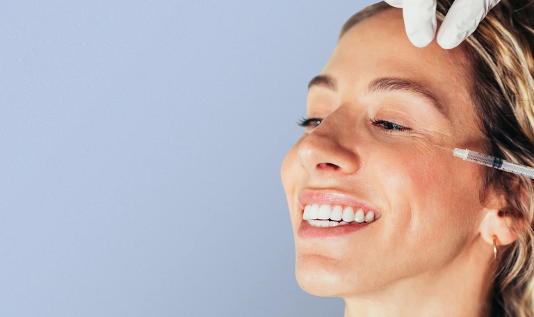 A women getting injectables treatment with a syringe on her face